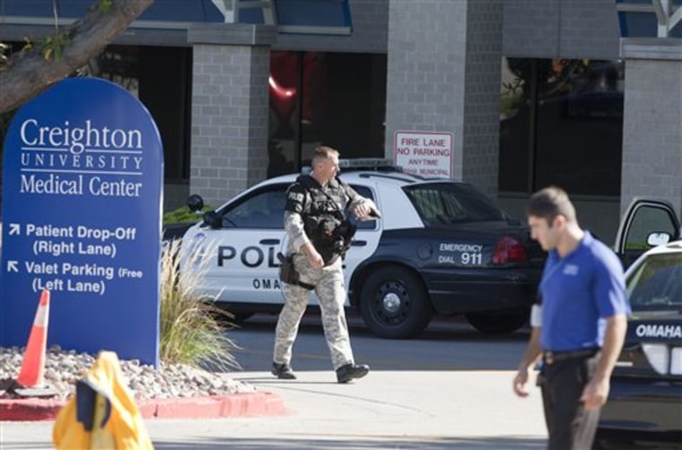 A police SWAT team member walks out of the Creighton University medical center in Omaha, Neb., on Wednesday. Two officers were hurt and a suspect was fatally wounded in a shooting at the facility.